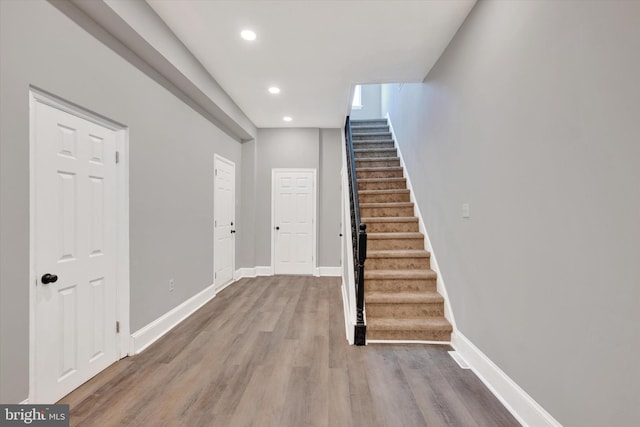 interior space featuring baseboards, recessed lighting, wood finished floors, and stairway