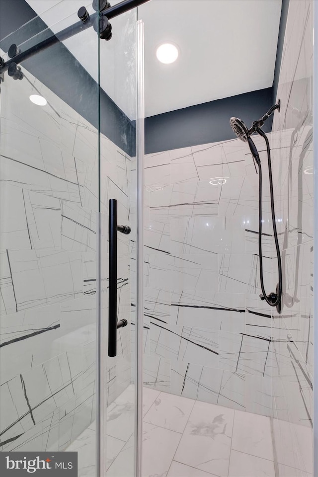 full bathroom with a marble finish shower