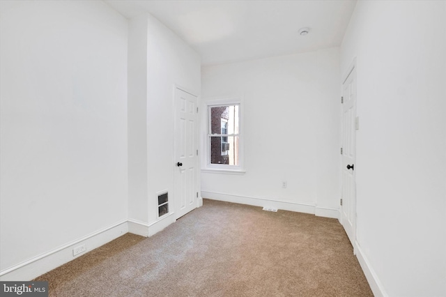 unfurnished room with carpet and baseboards
