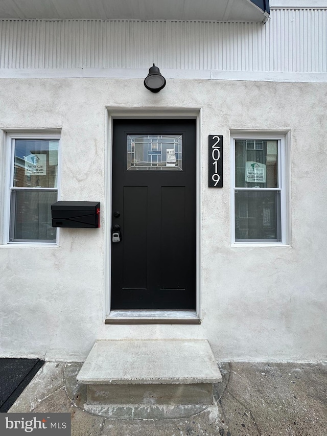 entrance to property with stucco siding