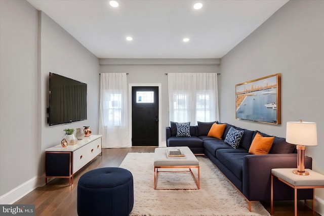 living area with baseboards, wood finished floors, and recessed lighting