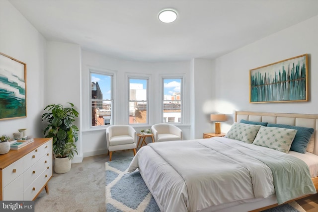 bedroom featuring light carpet and baseboards