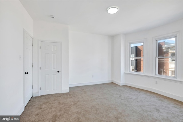 unfurnished room featuring baseboards and carpet