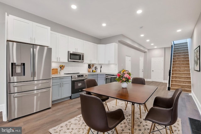 kitchen featuring light wood finished floors, stainless steel appliances, visible vents, decorative backsplash, and recessed lighting