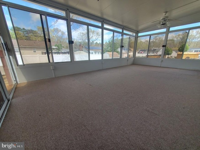 unfurnished sunroom featuring a ceiling fan