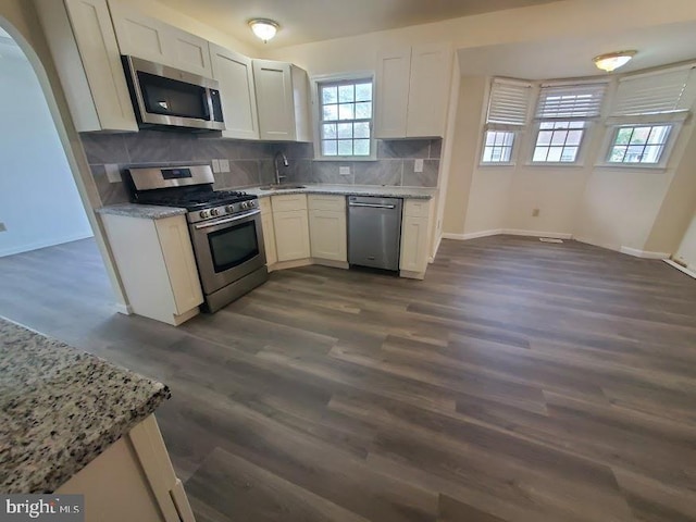 kitchen with a sink, appliances with stainless steel finishes, and baseboards