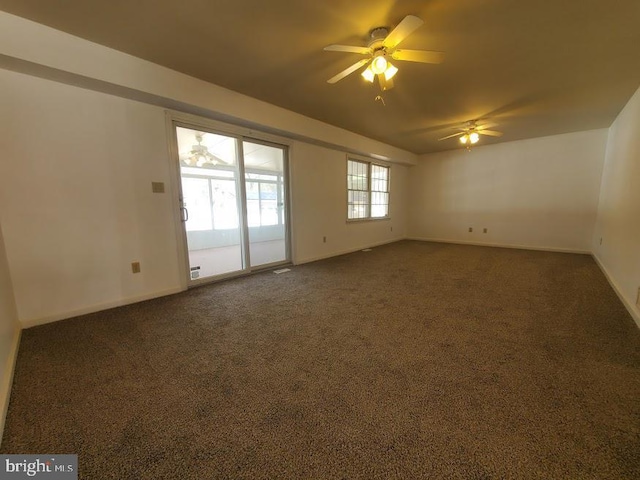 spare room featuring baseboards, a ceiling fan, and dark colored carpet