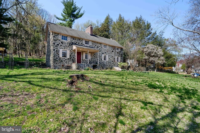 view of front of property with a chimney and a front yard