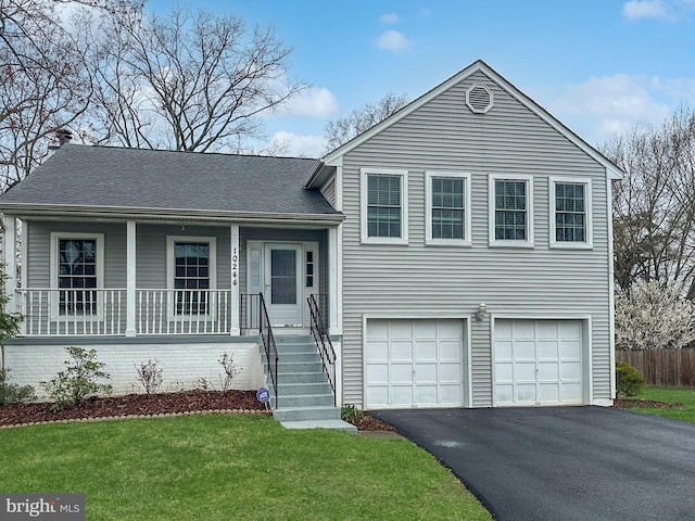 split level home with driveway, a front yard, covered porch, roof with shingles, and a garage