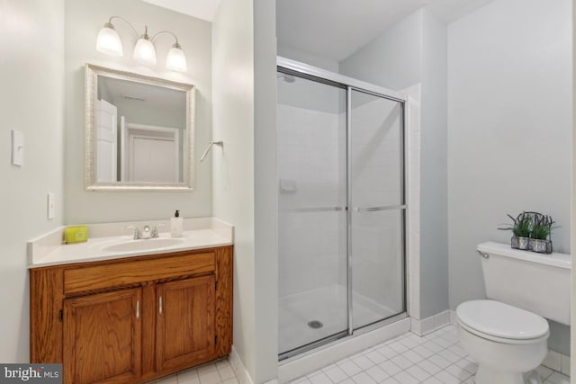 bathroom featuring tile patterned flooring, vanity, toilet, baseboards, and a stall shower