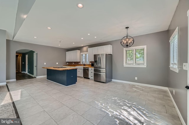 302 Haskell Dr, Arnold, MD 21012 - kitchen with appliances with stainless steel finishes, white cabinets, a center island, a sink, and arched walkways