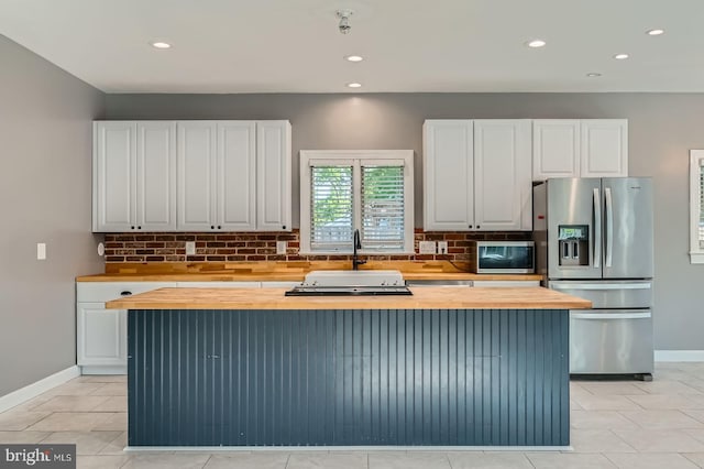 302 Haskell Dr, Arnold, MD 21012 - kitchen featuring butcher block counters, appliances with stainless steel finishes, decorative backsplash, white cabinetry, and a center island