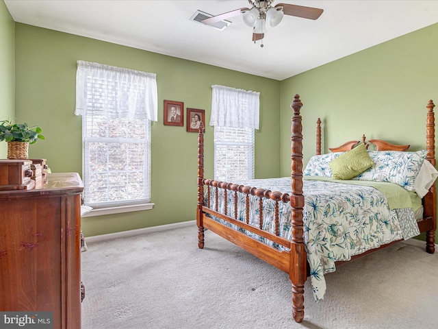 carpeted bedroom with visible vents, a ceiling fan, and baseboards