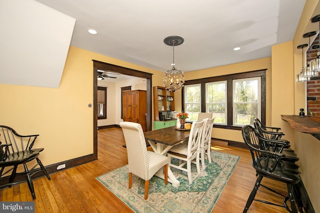 dining room featuring recessed lighting, light wood-style flooring, baseboards, and ceiling fan with notable chandelier