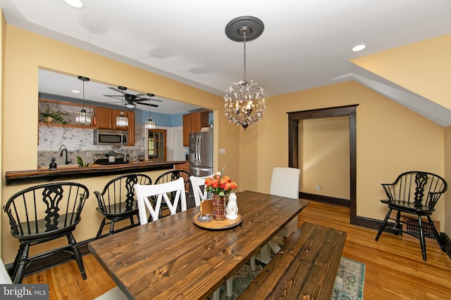 dining space featuring ceiling fan with notable chandelier, baseboards, light wood-style floors, and recessed lighting