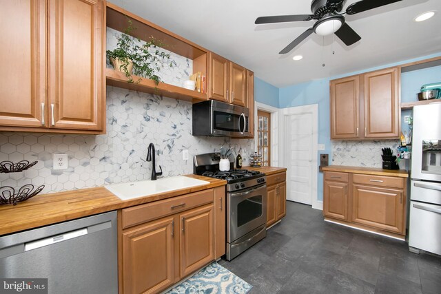 kitchen with stainless steel appliances, open shelves, a ceiling fan, a sink, and decorative backsplash