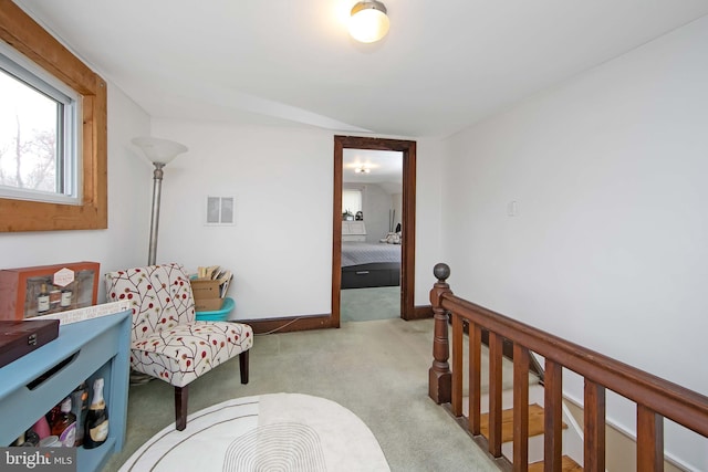 living area with baseboards, visible vents, carpet floors, and an upstairs landing