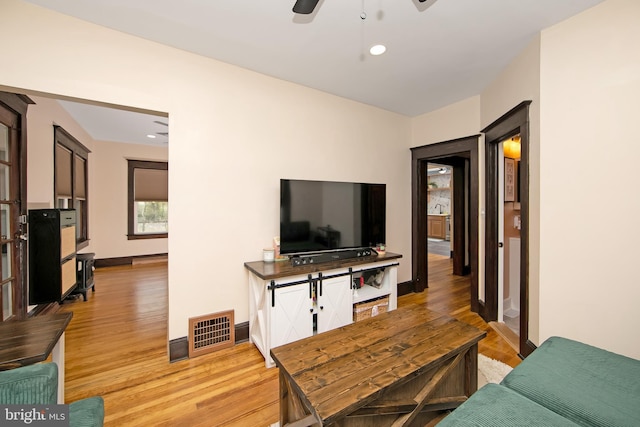 living room featuring baseboards, visible vents, recessed lighting, light wood-style floors, and ceiling fan