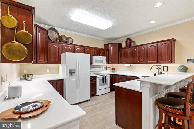 13113 Little Hayden Cir Unit 87, Hagerstown, MD 21742 - kitchen featuring light wood-style floors, white appliances, a kitchen breakfast bar, a peninsula, and a sink