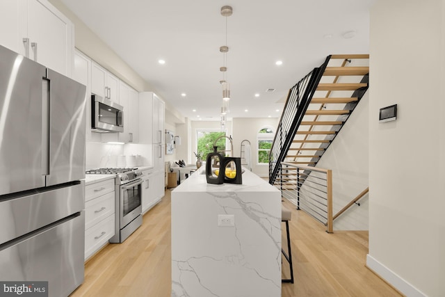 41 Q St NE Unit 2, Washington, DC 20002 - kitchen featuring appliances with stainless steel finishes, a center island, white cabinets, light wood finished floors, and recessed lighting