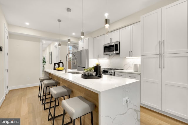 41 Q St NE Unit 2, Washington, DC 20002 - kitchen with stainless steel appliances, a sink, an island with sink, white cabinets, and recessed lighting
