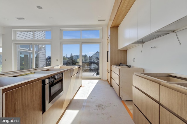 318 York Rd, South Bethany, DE 19930 - kitchen with concrete flooring, light countertops, wall oven, and modern cabinets