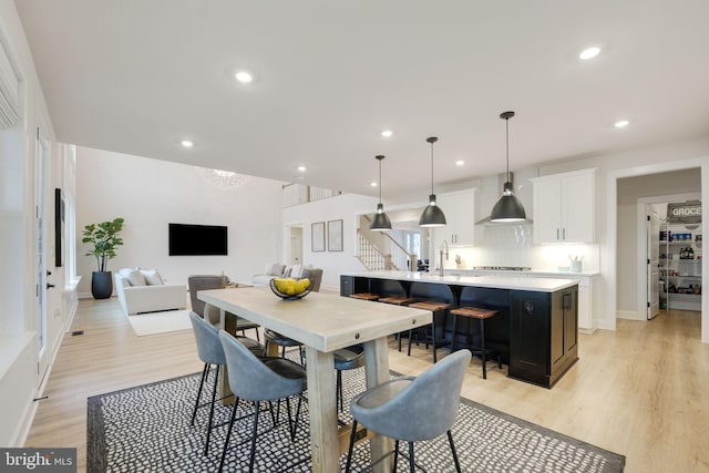 dining space with recessed lighting, light wood-style floors, and baseboards