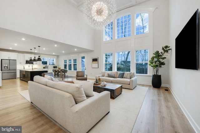 living area featuring light wood-style flooring, baseboards, and plenty of natural light
