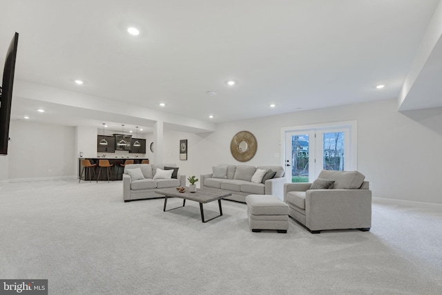 living room featuring baseboards, recessed lighting, and light carpet