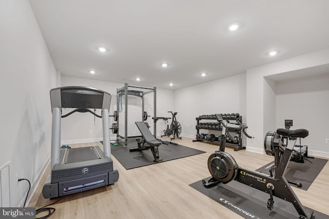 exercise area with wood finished floors, baseboards, visible vents, and recessed lighting