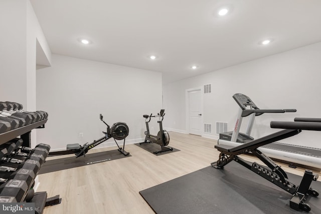 exercise area featuring visible vents, light wood-type flooring, and baseboards