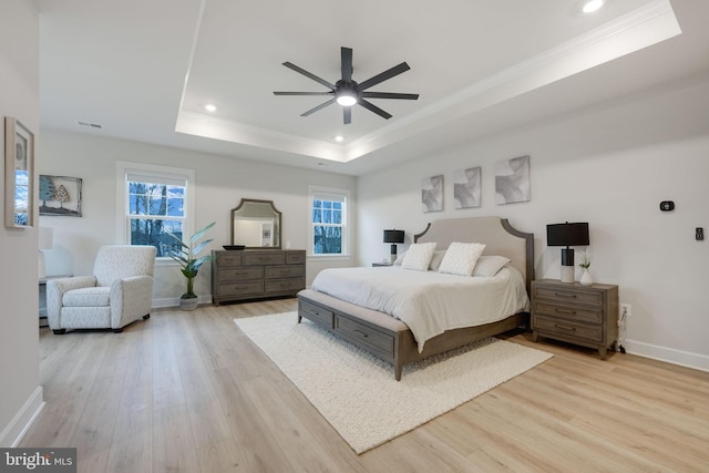 bedroom with crown molding, recessed lighting, wood finished floors, a raised ceiling, and baseboards