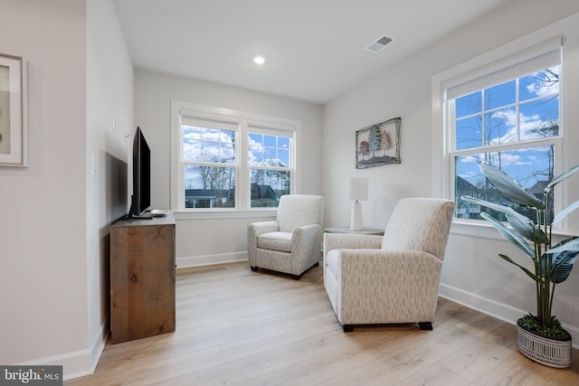 living area with light wood-type flooring, baseboards, visible vents, and recessed lighting