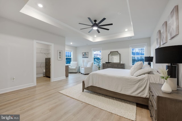 bedroom with baseboards, a raised ceiling, crown molding, recessed lighting, and light wood-style flooring