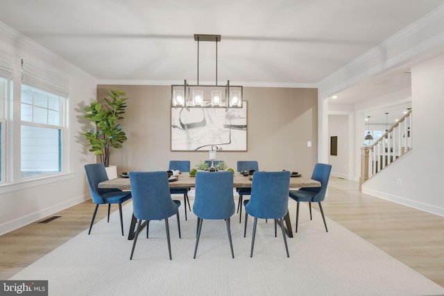 dining space with ornamental molding, baseboards, and wood finished floors