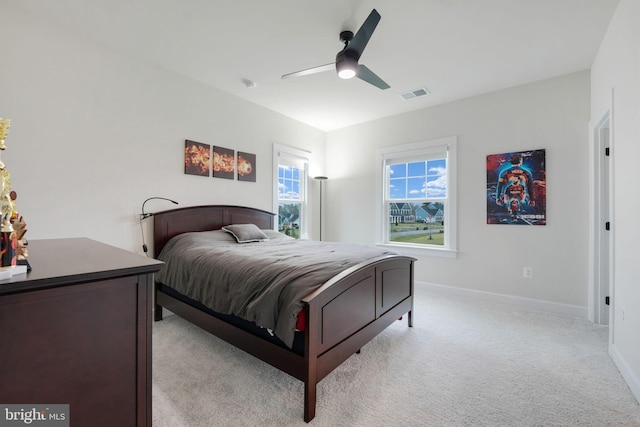 bedroom with light carpet, baseboards, a ceiling fan, and visible vents