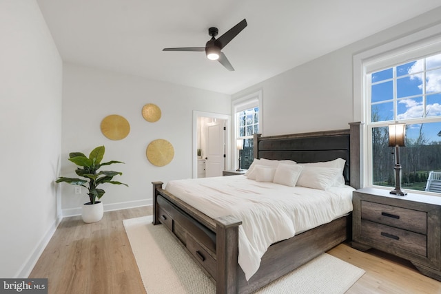 bedroom with baseboards, light wood-type flooring, and a ceiling fan