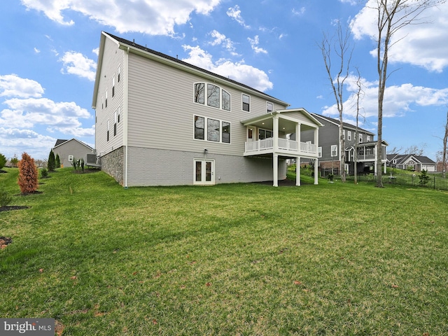 rear view of property featuring a yard, french doors, and a wooden deck