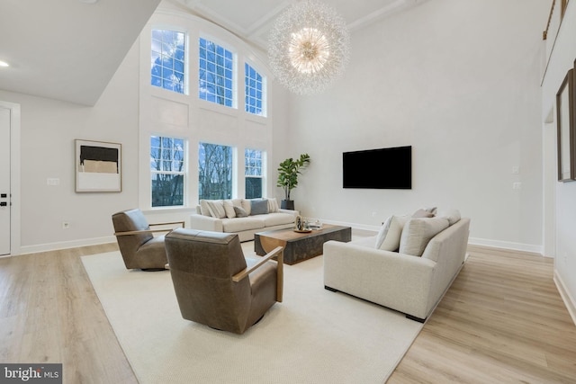 living room featuring baseboards, light wood finished floors, and an inviting chandelier
