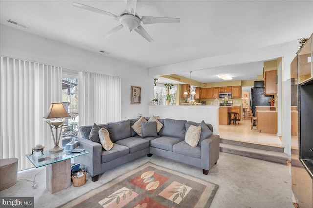 living area with a ceiling fan and visible vents