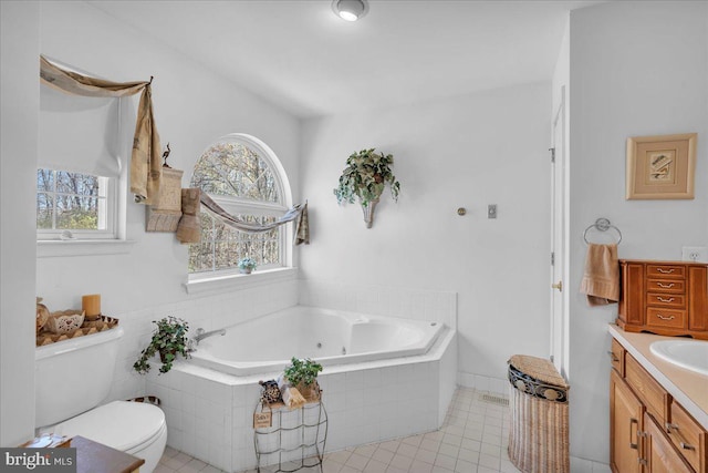 full bathroom with toilet, tile patterned floors, vanity, and a tub with jets