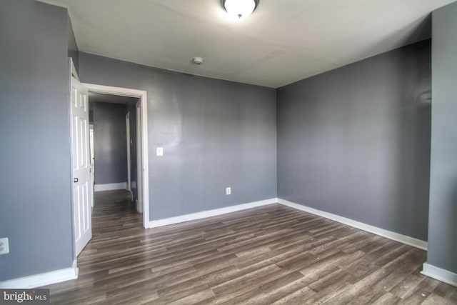 unfurnished room featuring dark wood finished floors and baseboards
