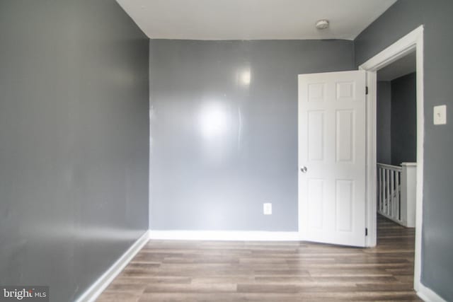 spare room featuring wood finished floors and baseboards