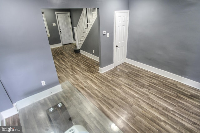 interior space featuring baseboards, wood finished floors, and stairs