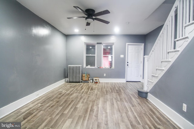 foyer featuring ceiling fan, baseboards, radiator heating unit, and wood finished floors