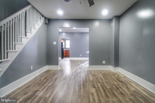 interior space featuring wood finished floors, a ceiling fan, baseboards, and stairway