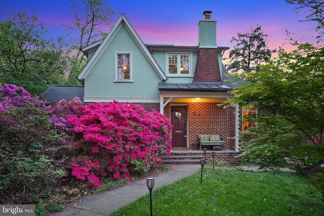 7812 Takoma Ave, Takoma Park, MD 20912 - view of front of home with a chimney, brick siding, a standing seam roof, stucco siding, and metal roof