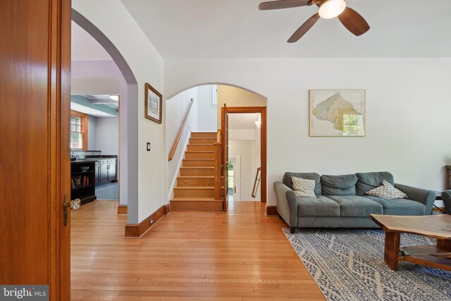 7812 Takoma Ave, Takoma Park, MD 20912 - living room with ceiling fan, stairway, light wood-type flooring, arched walkways, and baseboards