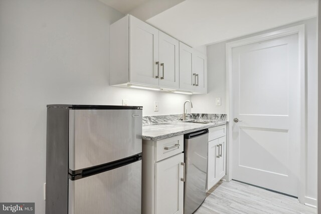 7812 Takoma Ave, Takoma Park, MD 20912 - kitchen featuring freestanding refrigerator, a sink, light wood finished floors, refrigerator, and light stone countertops