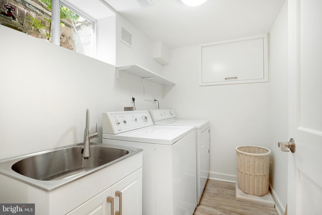 7812 Takoma Ave, Takoma Park, MD 20912 - laundry room with washing machine and dryer, light wood-style flooring, baseboards, and cabinet space